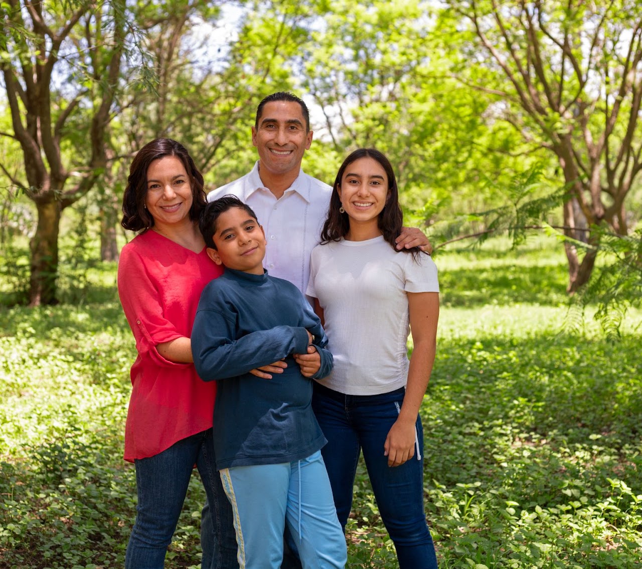 vista-frontal-familia-sonriente-afuera